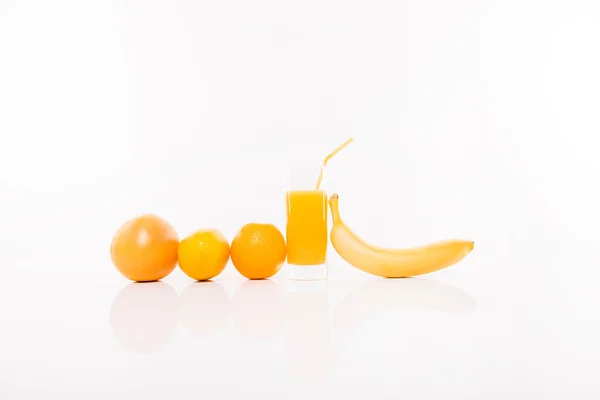 Range of orange fruits and glass of juice — Stock Photo, Image