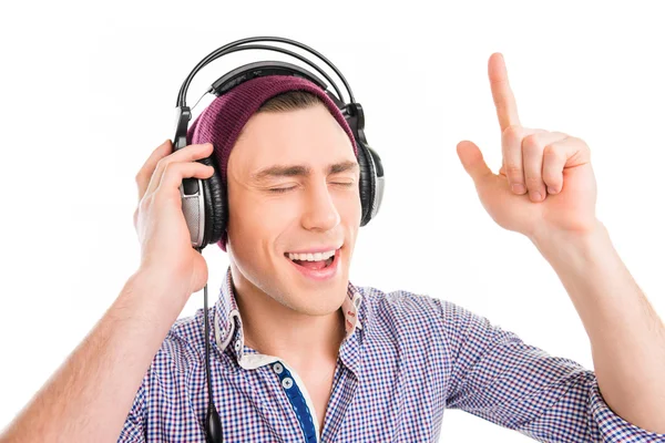 Человек в кепке и наушниках слушает музыку и жестикулирует раем — стоковое фото