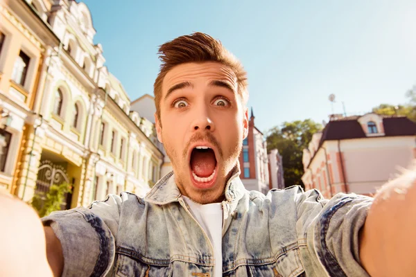 Handsome man making selfie and grimacing with opened mouth — Stock Photo, Image