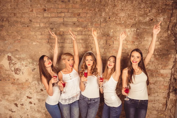 Chicas lindas celebrando despedida de soltera con las manos levantadas y copas — Foto de Stock