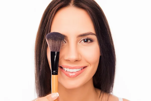 Primer plano retrato de mujer bonita sosteniendo cepillo de maquillaje cerca de ojo — Foto de Stock