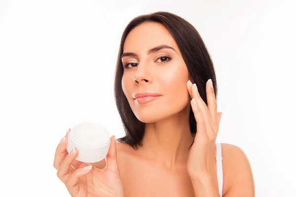 Beautiful pretty young woman applying cream on her face — Stock Photo, Image