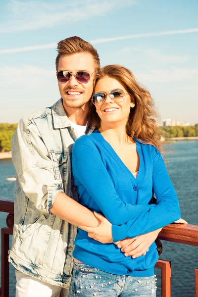 Щасливий чоловік і жінка в окулярах обіймають один одного на брилі — стокове фото