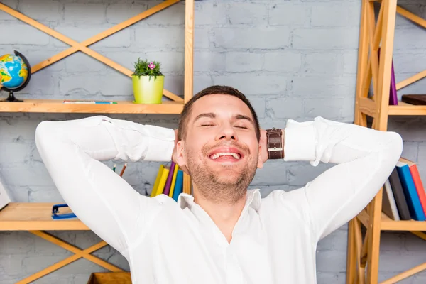 Närbild porträtt av lycklig trött man avkopplande i office — Stockfoto