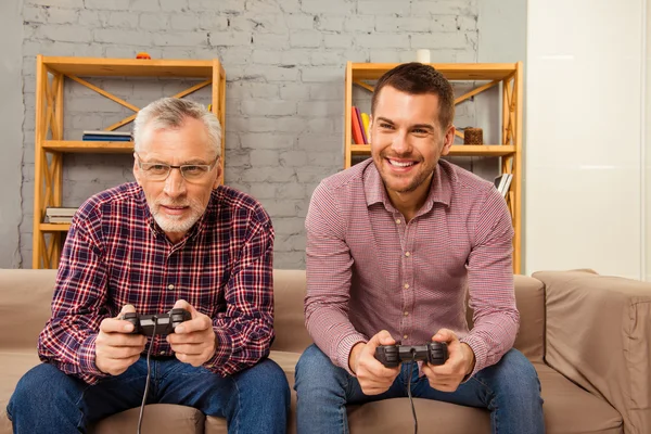 Bello padre e suo figlio giocare ai videogiochi e ridere wh — Foto Stock