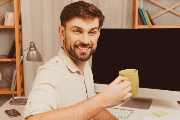 Feliz sorrindo jovem trabalhador ter pausa e beber chá — Fotografia de Stock
