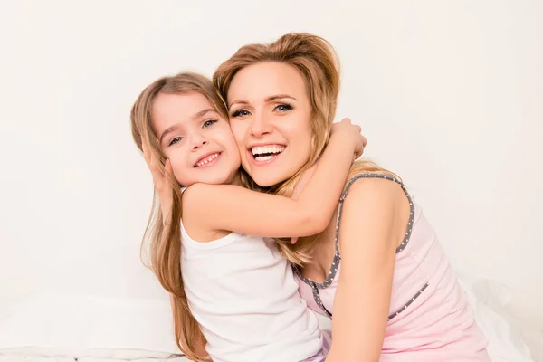 Közelről portréja mosolygós kislány és huging anyja — Stock Fotó