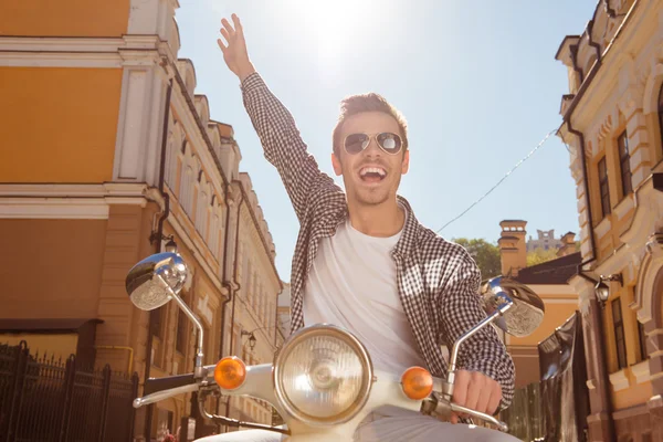 Handsome happy man riding a motorbike picking up one hand — Stock Photo, Image