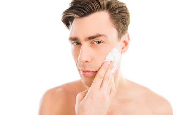 Handsome man smearing foam for shave on his face — Stock Photo, Image