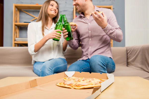 男と女のピザを食べて、ビールのボトルとチャリン — ストック写真