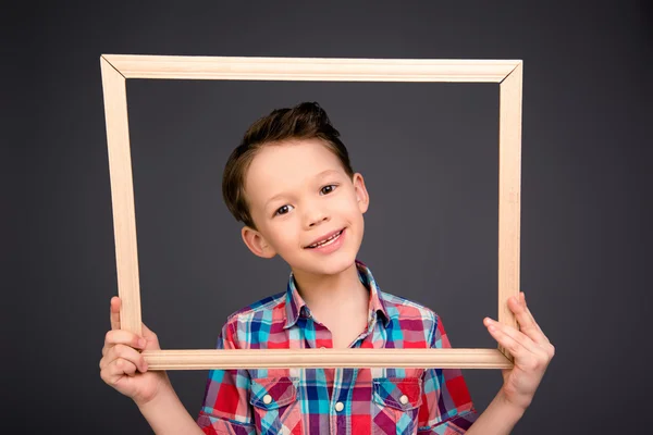 Glad liten pojke håller träram — Stockfoto