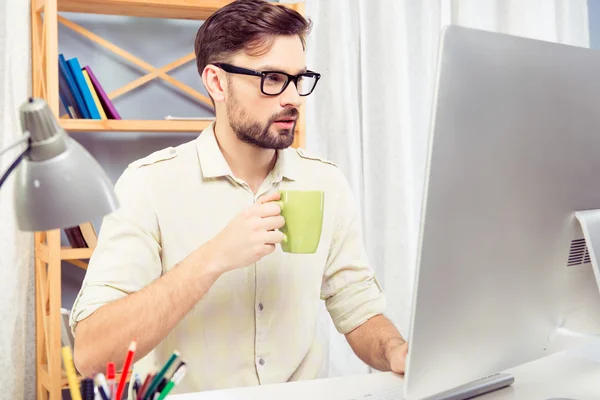 De cerca la foto de un joven en gafas de beber café en offic —  Fotos de Stock