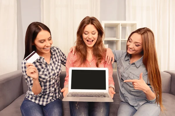Tre flickor sitter på soffan och visar svart skärm på laptop en — Stockfoto