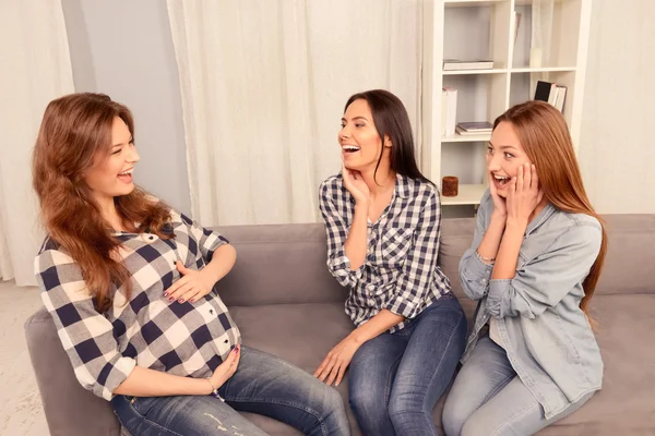 Έγκυο γυναίκα και τους φίλους της να κάθεται στον καναπέ και το γέλιο — Φωτογραφία Αρχείου