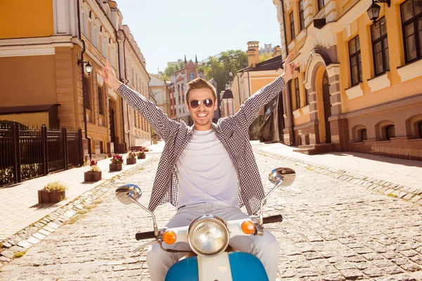 Knappe gelukkig man rijden een motorfiets oppakken van beide handen — Stockfoto