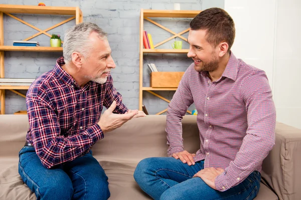 Conversación de dos guapo hombre adulto sentado en el sofá — Foto de Stock