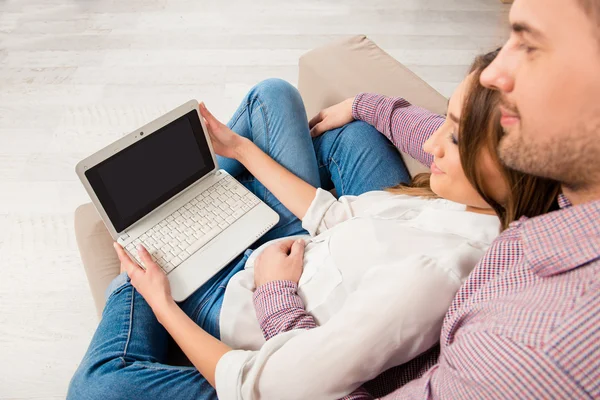 Retrato de vista superior de pareja feliz sentada en el sofá con el ordenador portátil — Foto de Stock