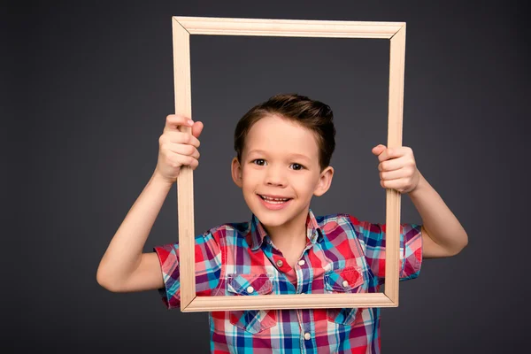 Porträtt av positiva leende liten pojke håller ram — Stockfoto