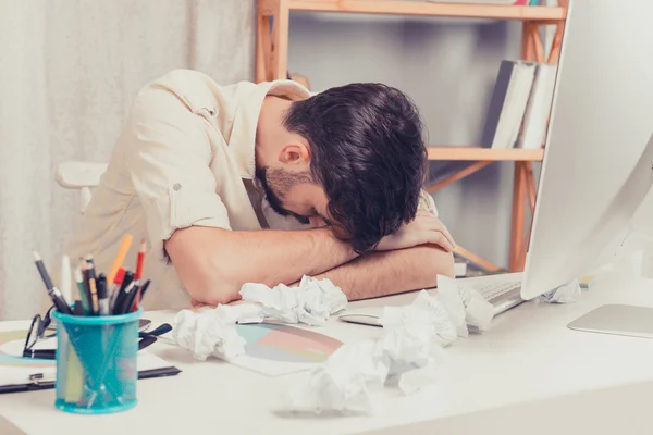 Trött man sova på arbete, skrynklade papper på bordet — Stockfoto