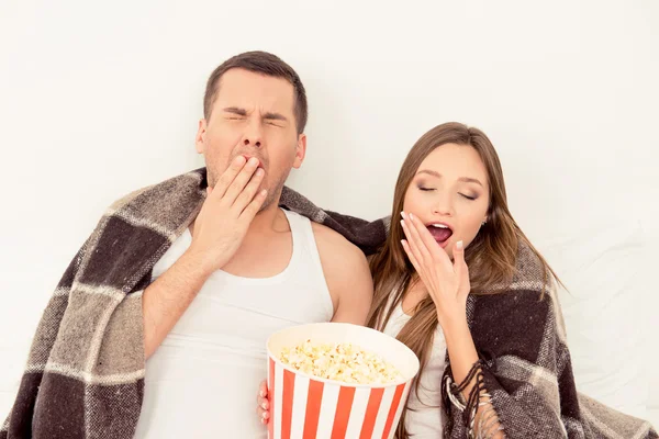 Couple in love sitting with popcorn and yawning while watching f — Stock Photo, Image