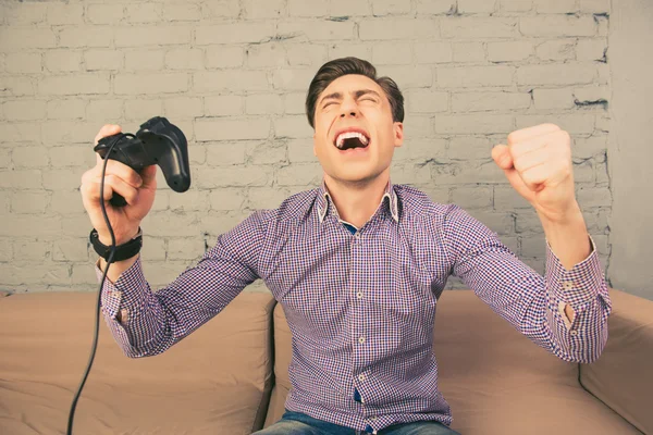 Porträt eines glücklichen jungen Mannes, der schreit und den Steuerknüppel hält — Stockfoto