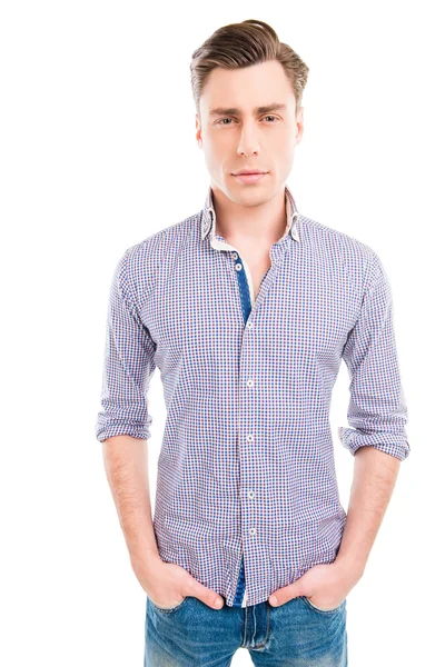 Portrait of serious young man holding hands in pockets of jeans — Stock Photo, Image