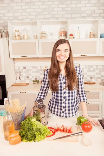 Portret van huisvrouw in de keuken met groenten en spaghet — Stockfoto