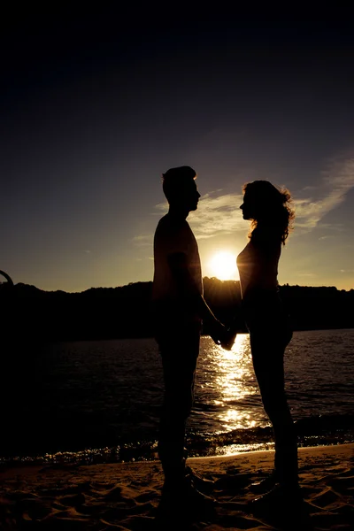 Silhouette di uomo e donna romantico che si tengono per mano al tramonto — Foto Stock