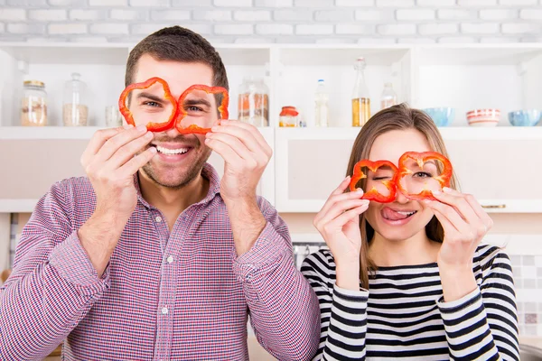 Komische paar verliefd segmenten van peper in de buurt van de ogen en de Toon te houden — Stockfoto