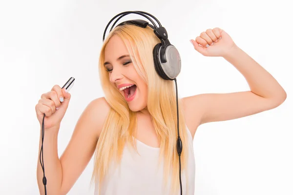 Glad tjej lyssnar musik i hörlurar och sjunga — Stockfoto