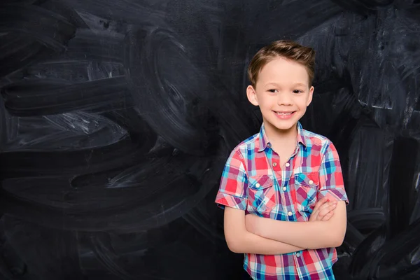 Portrat av glada leende liten pojke med korsade händer — Stockfoto