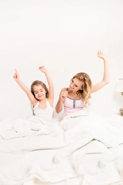 若い女性と彼女の娘が目を覚ます、t に手を伸ばす — ストック写真