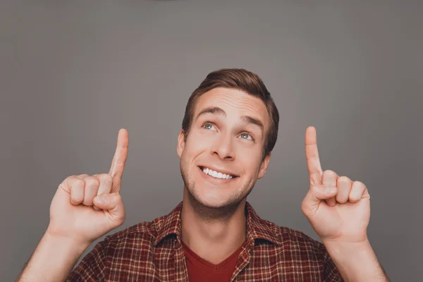 Portrait of cheerful young man pointing up with fingers — Stock Photo, Image