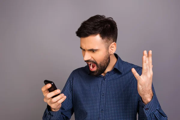 Retrato de um jovem furioso gritando em seu celular — Fotografia de Stock