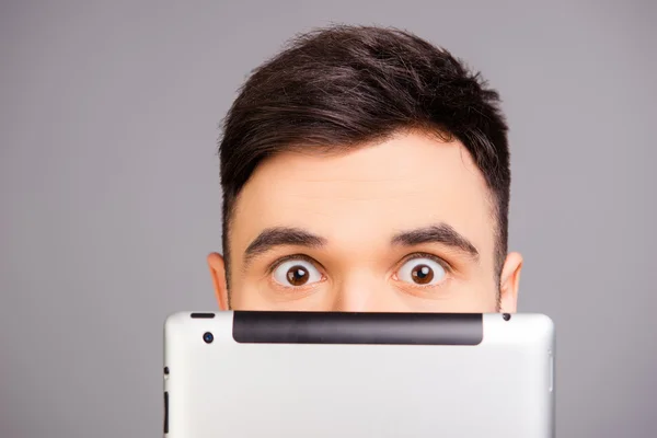 Close up retrato de jovem escondendo seu rosto atrás tablet — Fotografia de Stock