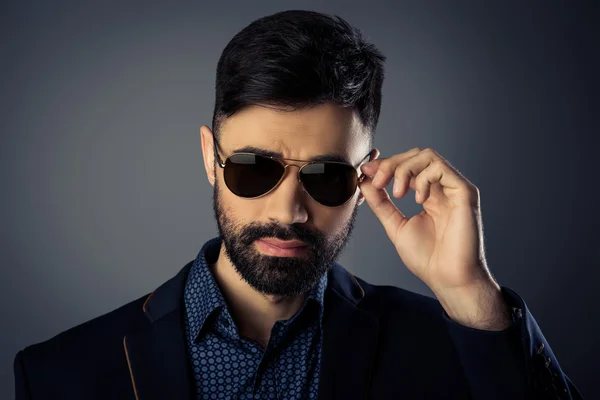 Portrait of trendy man in suit touching his spectacles — Stock Photo, Image