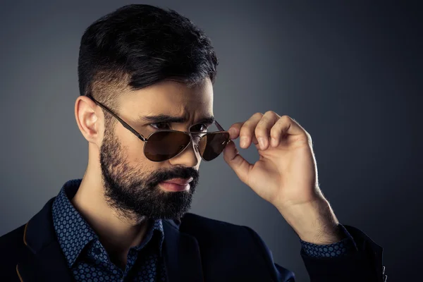 Portrait of brutal trendy man in jacket and spectacles — Stock Photo, Image