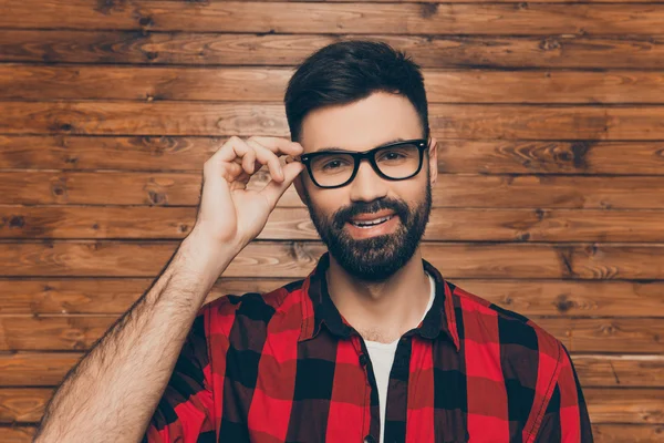 Bonito jovem sorrindo homem tocando seus óculos — Fotografia de Stock