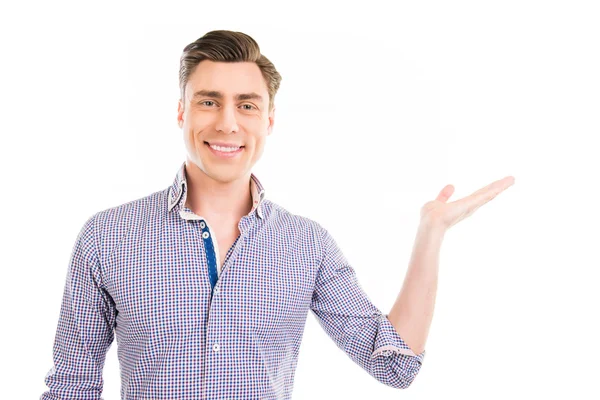 Cheerful young man gesturing with hand and showing product — Stock Photo, Image