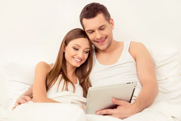 Happy man and woman in love reading news on tablet — Stock Photo, Image