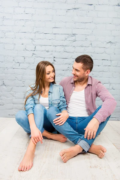 Junges verliebtes Paar sitzt auf dem Boden und schaut einander zu — Stockfoto