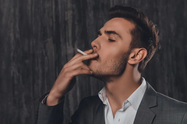 Закрыть портрет симпатичного бизнесмена, курящего сигарет — стоковое фото