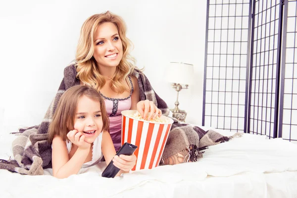 Opgewonden moeder en dochter tv kijken en eten popcorn — Stockfoto