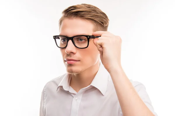 Привлекательный молодой человек в белой рубашке трогает очки — стоковое фото