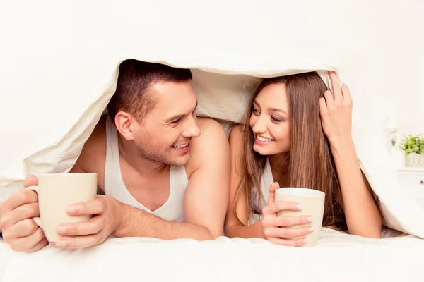 Веселий чоловік і жінка з ковдрою і гарячим чаєм — стокове фото