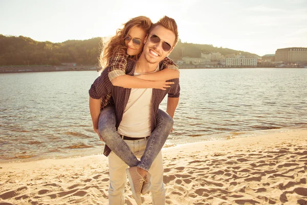 행복 한 젊은 사람이 해변에 그의 예쁜 여자를 편승 — 스톡 사진