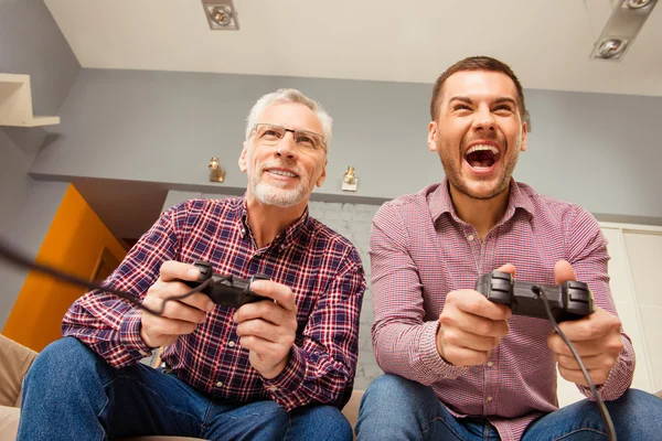 Крупный план портрета двух возбужденных красивых мужчин, играющих в видеоигры — стоковое фото