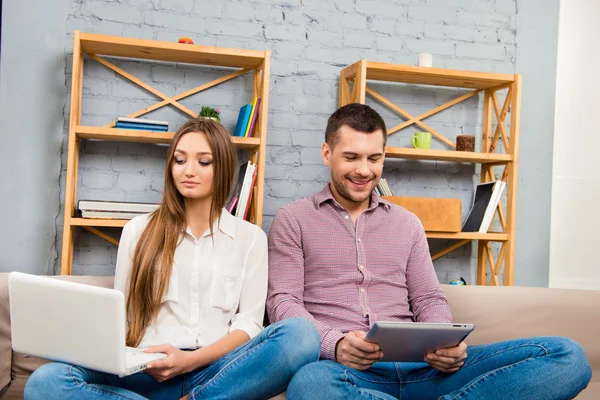 Lycklig sinnad man och kvinna som arbetar på bärbara datorer och Tablet PC — Stockfoto