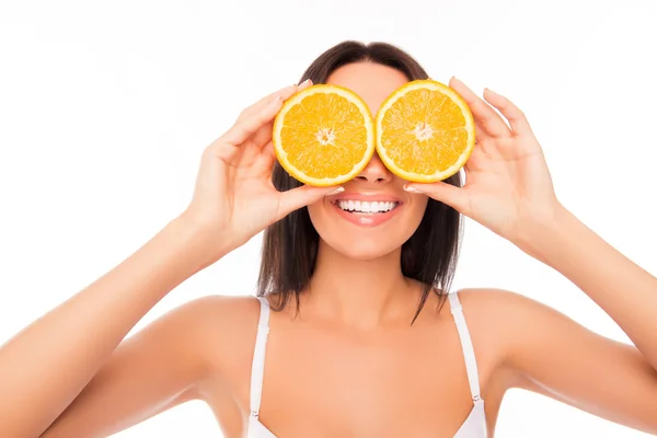 Primer plano retrato de la mujer divertida sosteniendo naranja cerca de los ojos — Foto de Stock