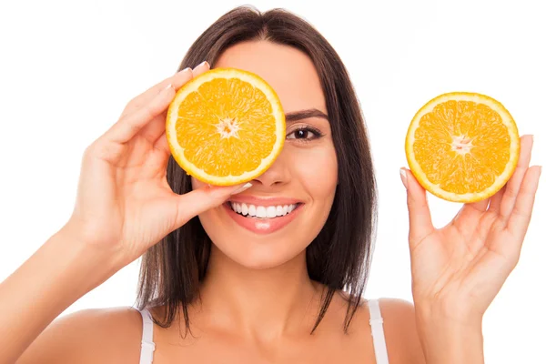 Menina cômica feliz com sorriso radiante segurando metades de néia laranja — Fotografia de Stock